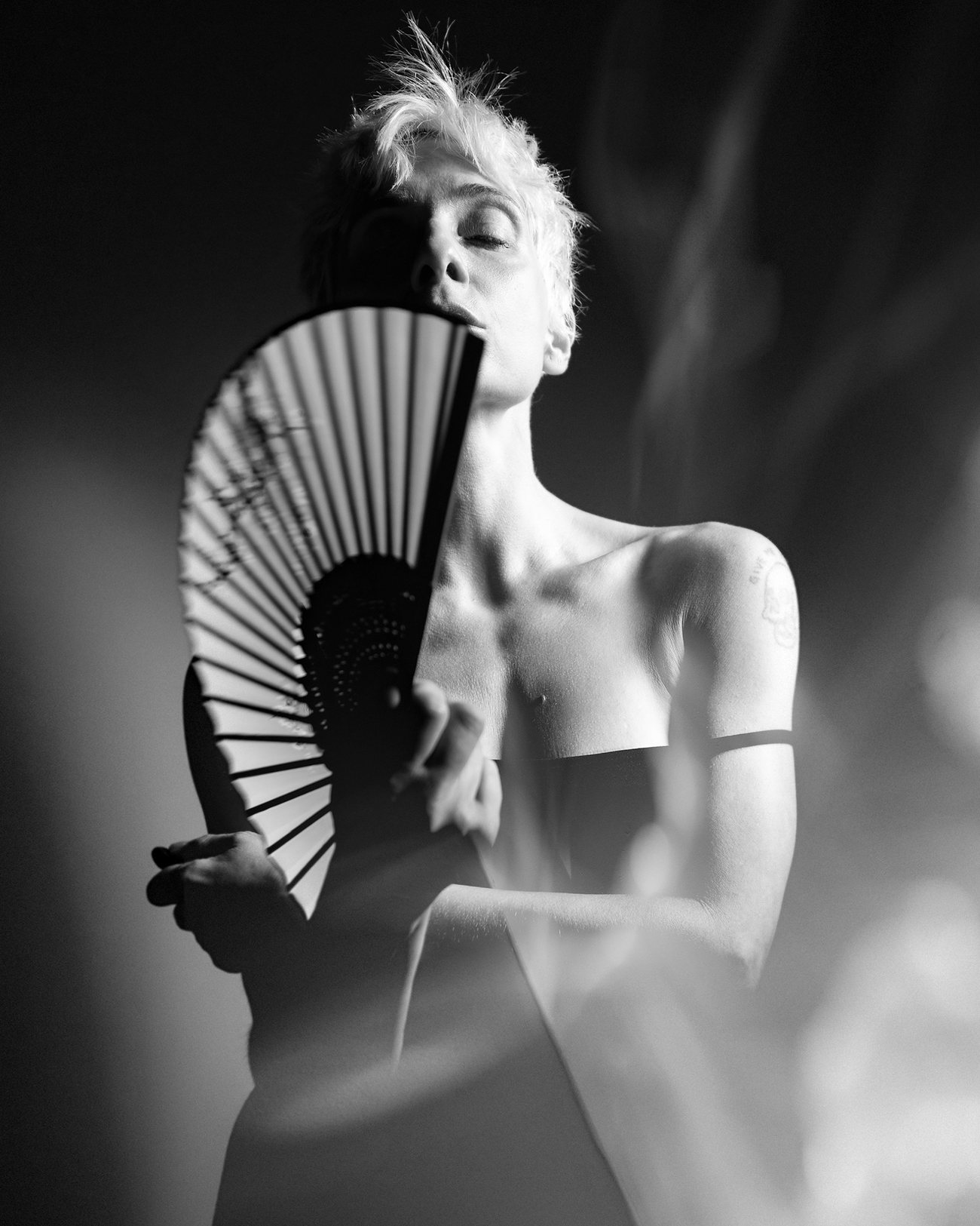 Self-portrait by Quina Mons with a folding fan, black and white